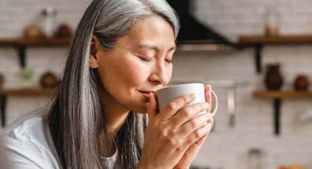 Cup of hot green tea with fresh leaves beside it, illustrating how drinking tea may support weight loss when paired with a healthy lifestyle.