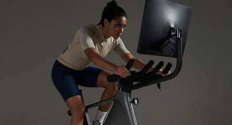 Person riding a bicycle on a scenic road, showing how cycling can help beginners lose weight and improve overall fitness.