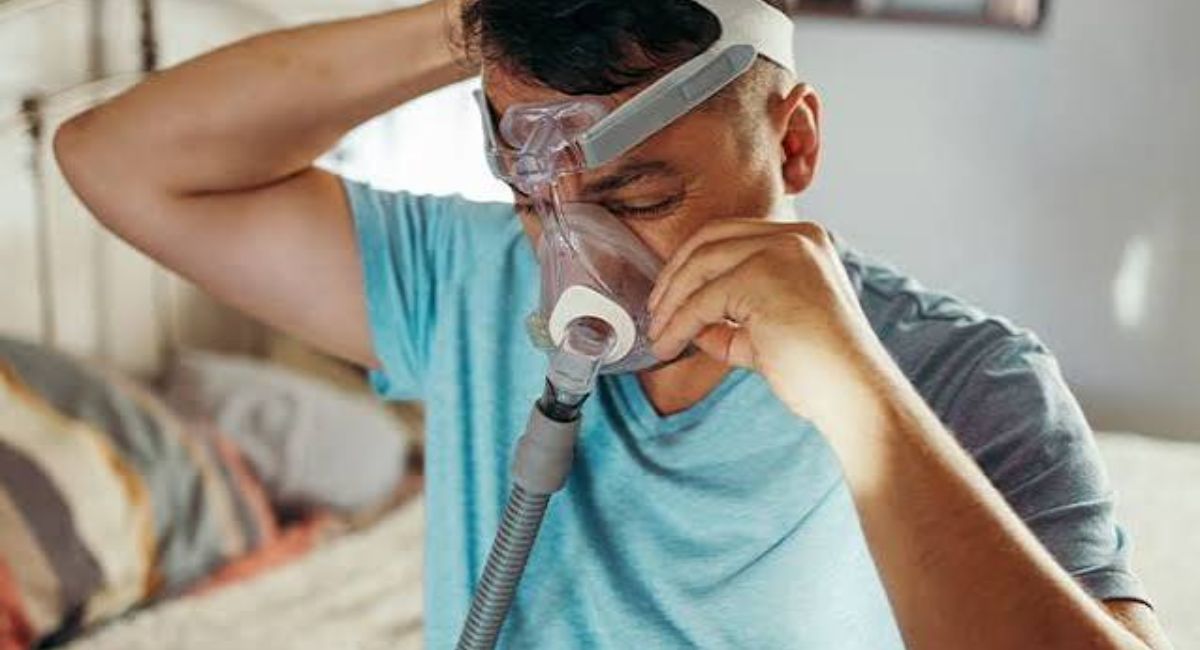 Person using a CPAP machine after weight loss, illustrating how losing weight may reduce sleep apnea severity and CPAP dependence.